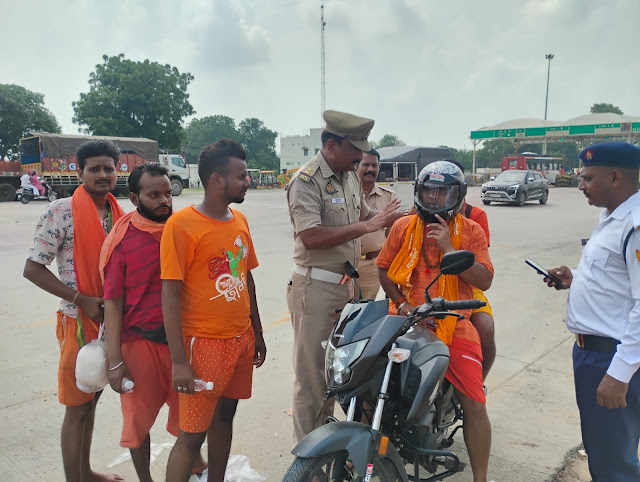 बाइक सवार कांवड़ियों को बांटे गए हेलमेट